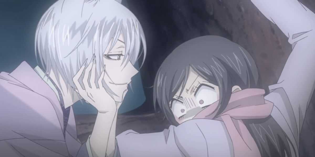 La imagen muestra una imagen de Kamisama Kiss: (De izquierda a derecha) Tomoe (cabello plateado y kimono violeta claro) se burla de Nanami Momozono (cabello largo y castaño, bufanda rosa y chaqueta morada).