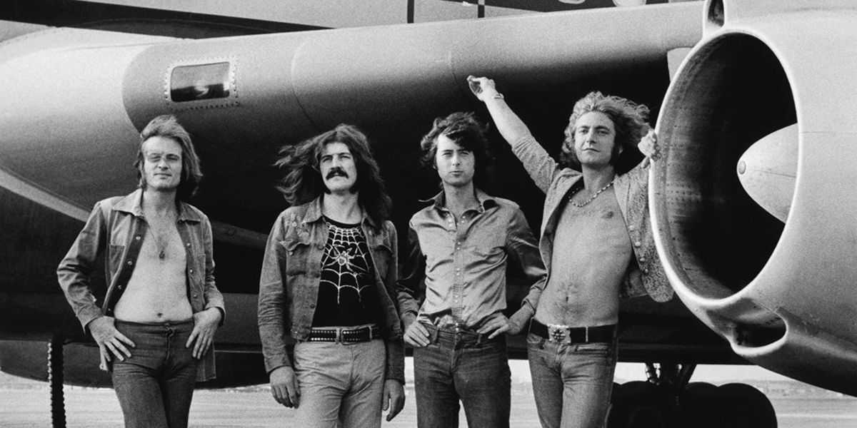 Miembros del grupo Led Zeppelin frente a un avión