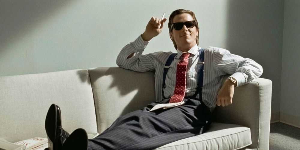 Patrick Bateman (Christian Bale) ležiaci na gauči vo filme American Psycho