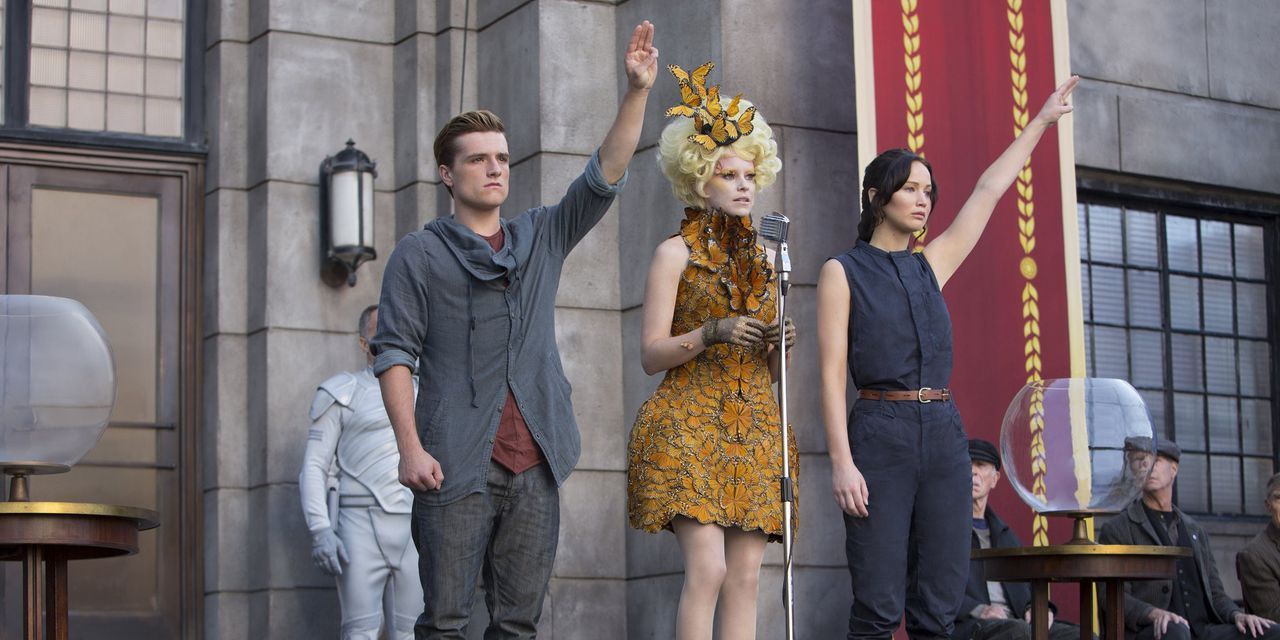 Peeta y Katniss saludan con tres dedos en la segunda cosecha de Los juegos del hambre.