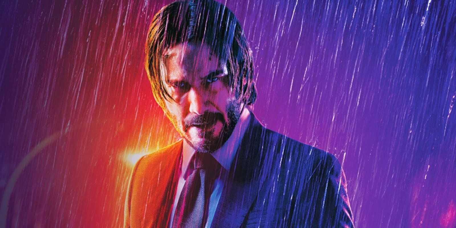 John Wick con traje y corbata parado bajo la lluvia
