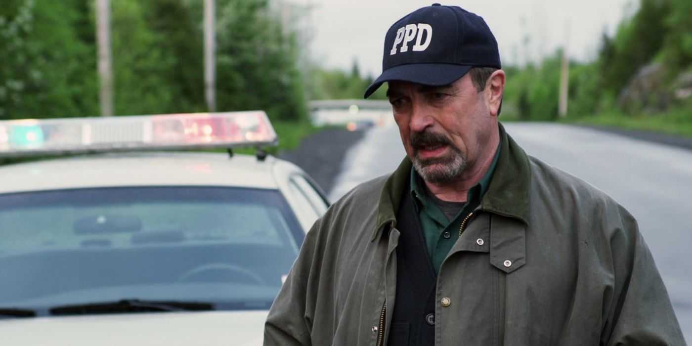 Jesse Stone junto a un coche de policía en Beneficio de la Duda