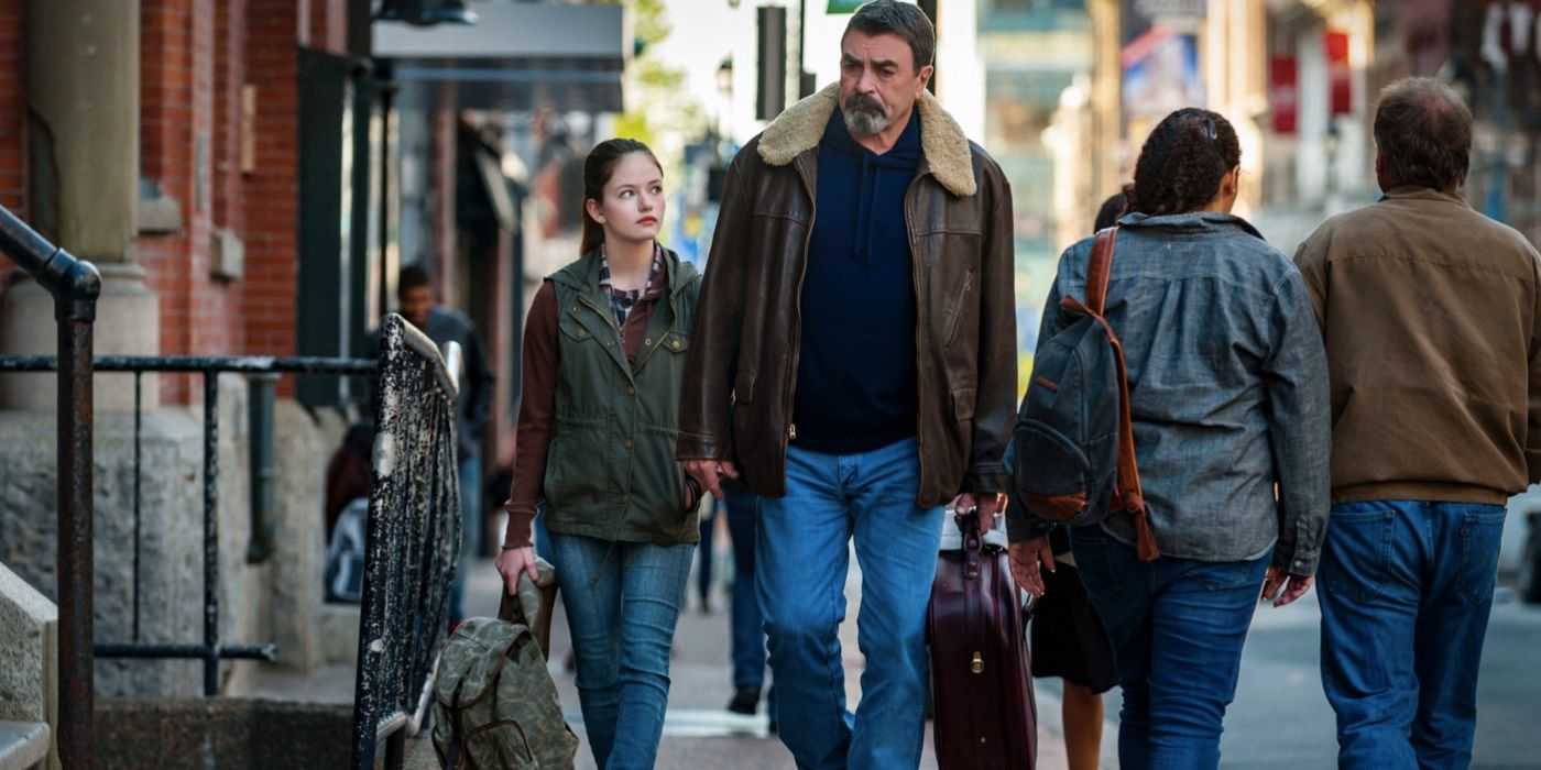 Jesse Stone caminando con una niña por la acera en Lost in Paradise