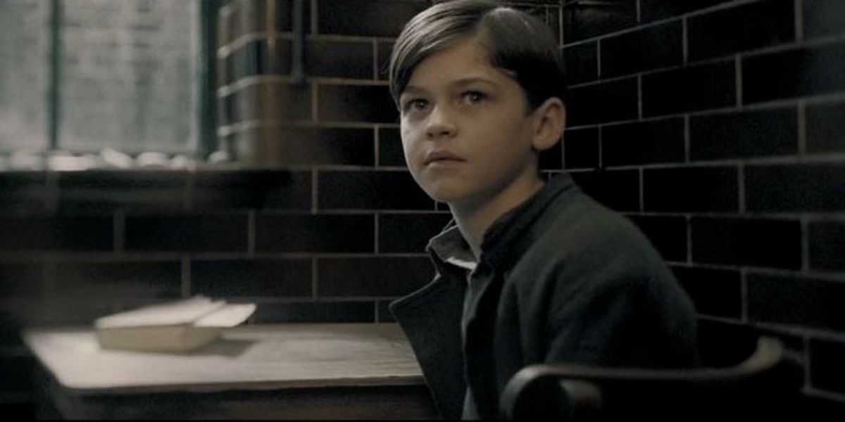 El héroe Fiennes-Tiffin como el joven Tom Riddle sentado en un escritorio en Harry Potter y el misterio del príncipe.
