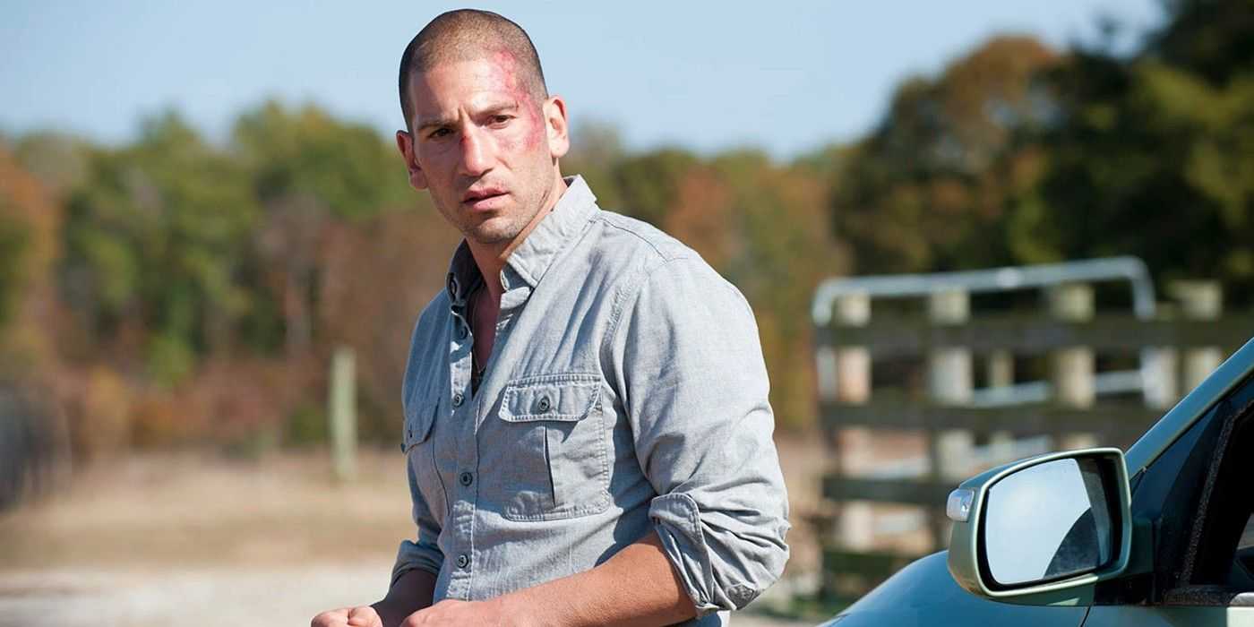 Shane Walsh steht neben einem Auto