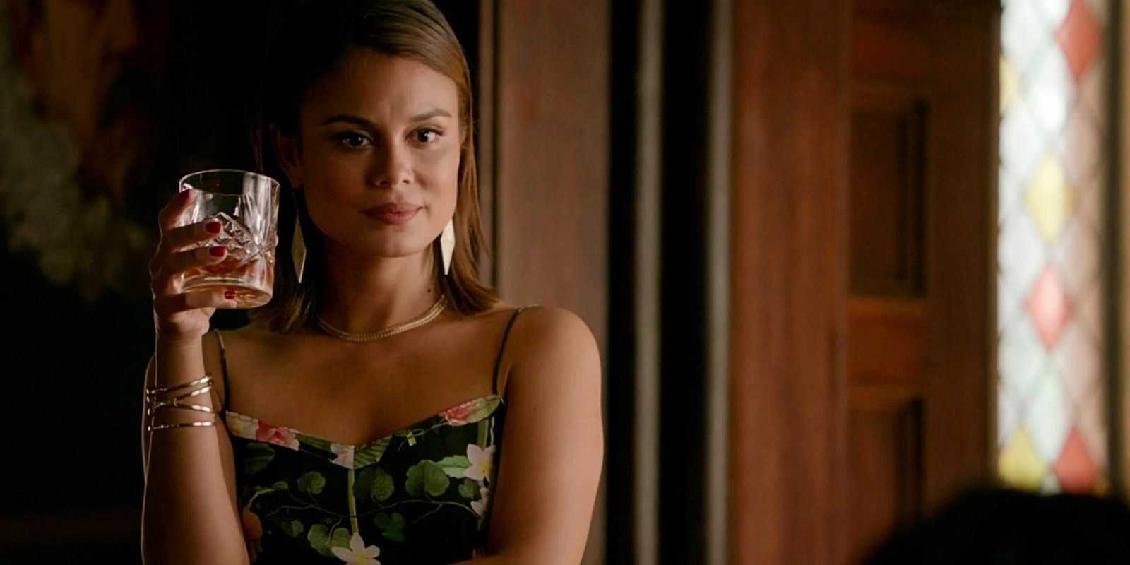 Sybil sostiene una bebida en The Vampire Diaries.