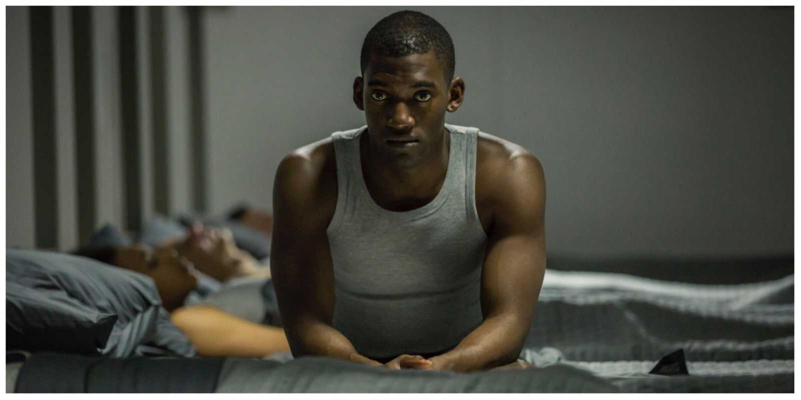 Stripe sitzt auf seinem Bett und denkt in Black Mirror nach