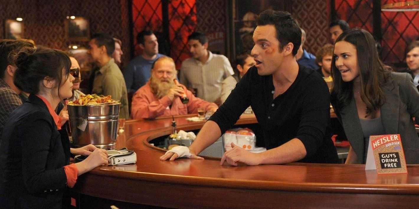 Jess sitzt an der Bar, als Shane in „New Girl“ hinter Nick auftaucht