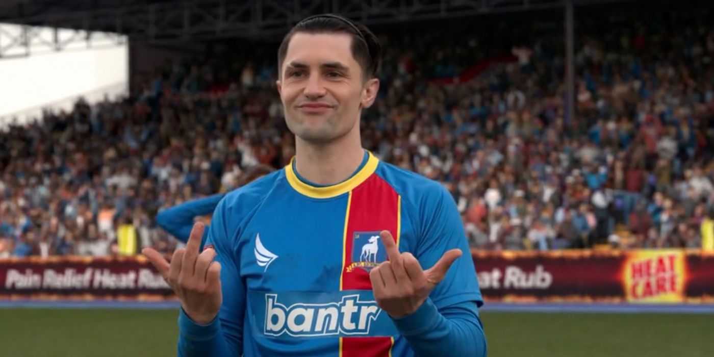 Jamie podáva prostredník trénerom a usmieva sa v scéne od Teda Lasa.