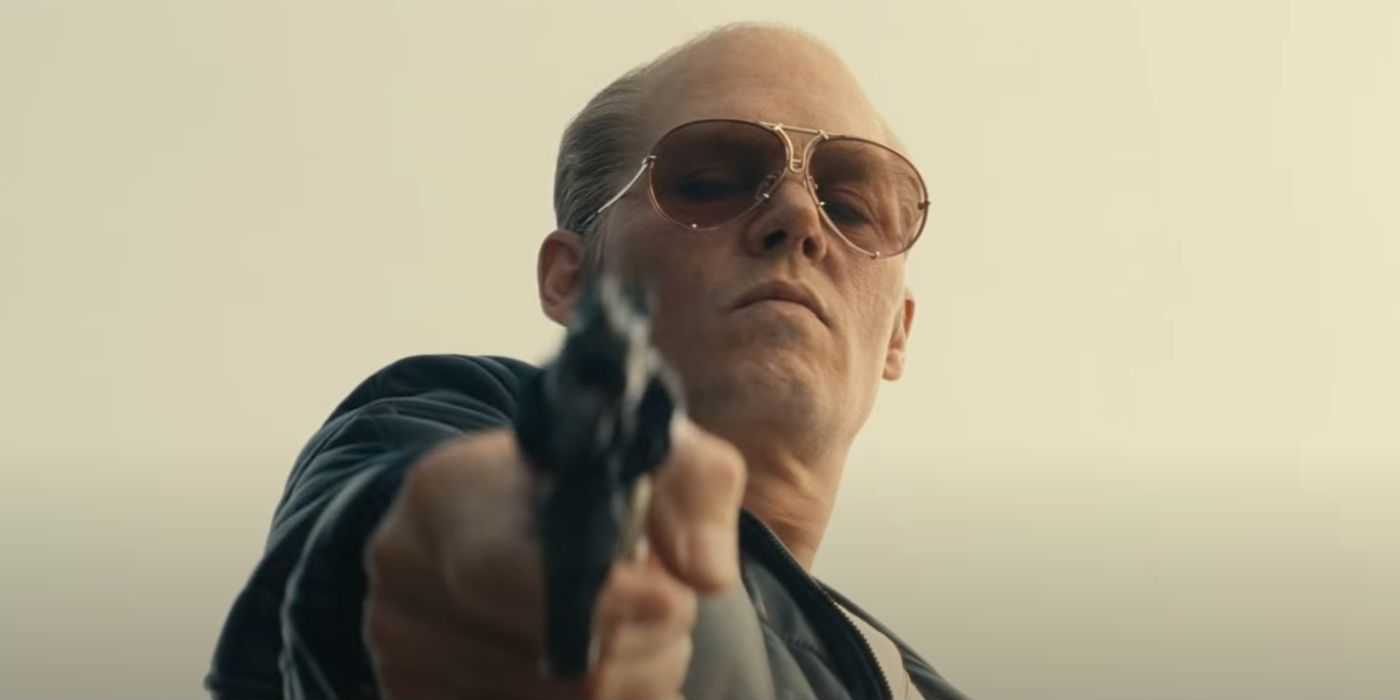 Johnny Depp als Whitey Bulger, der mit einer Waffe zielt
